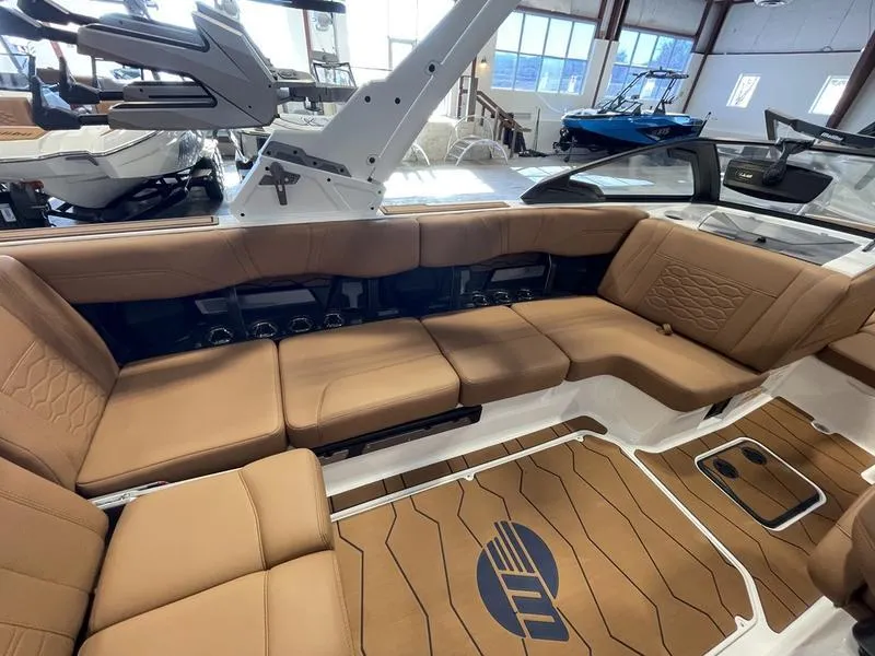Slide: The Image of 2025 Malibu 23 MXZ boat interior with tan seating and sleek design. - 6