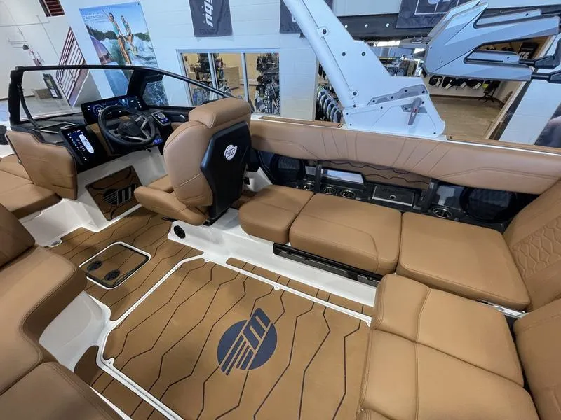 Slide: The Image of 2025 Malibu 23 MXZ boat interior with tan seating and modern dashboard. - 7