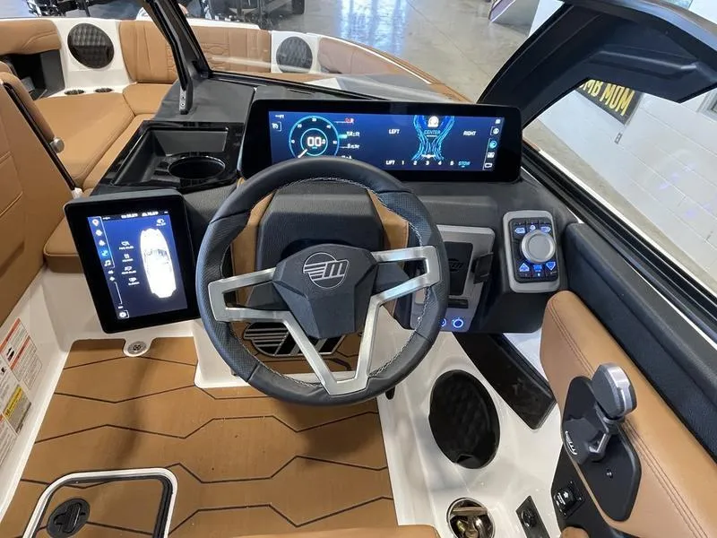 Slide: The Image of 2025 Malibu 23 MXZ boat dashboard with modern steering wheel and digital displays. - 9