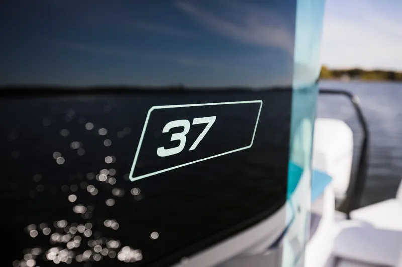 Slide: The Image of 2024 Axopar 37 XC Cross Cabin BRABUS Trim with wet bar cruising near a bridge. - 4