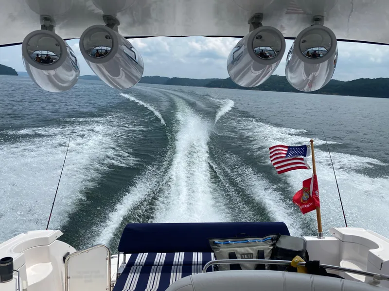 Slide: The Image of 2006 Regal Commodore 3560 IO cruising on a lake, American flag waving. - 11