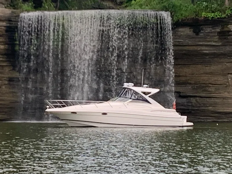 Slide: The Image of 2006 Regal Commodore 3560 IO boat cruising near a scenic waterfall. - 14