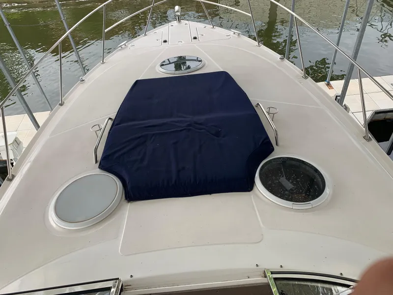 Slide: The Image of 2006 Regal Commodore 3560 IO boat deck with blue cover and circular windows. - 7