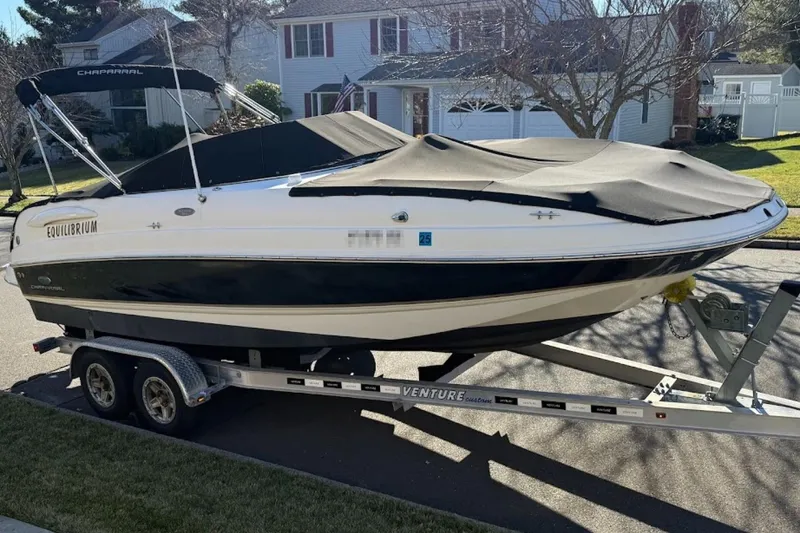 Slide: The Image of 2005 Chaparral 236 Sunesta boat on trailer, covered and parked in residential area. - 3