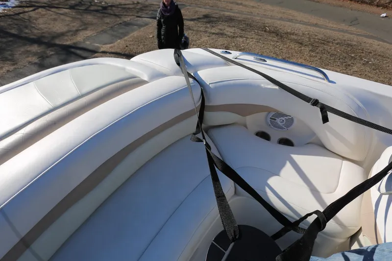 Slide: The Image of 2005 Chaparral 236 Sunesta boat interior with white seating and safety straps. - 9