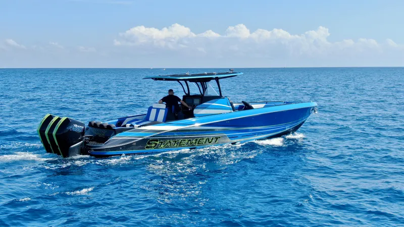 Slide: The Image of 2023 Statement 380 Open boat cruising on open blue sea with triple engines. - 15