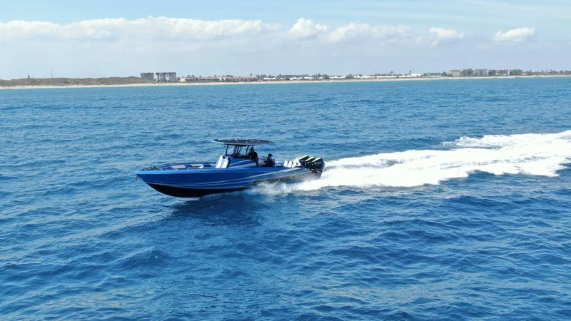 Slide: The Image of 2023 Statement 380 Open boat cruising on blue ocean near coastline. - 22