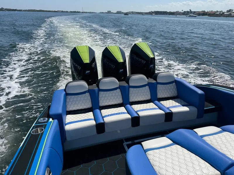 Slide: The Image of 2023 Statement 380 Open boat interior with blue and white seating on the water. - 31