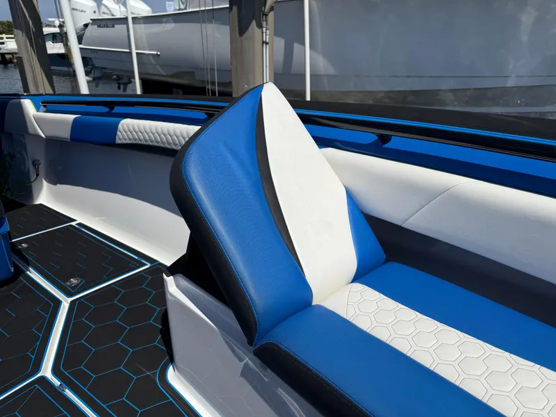 Slide: The Image of 2023 Statement 380 Open boat interior with blue and white seating, docked at marina. - 45