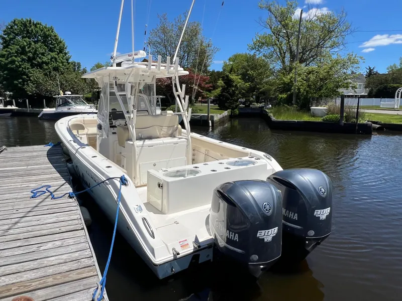 Slide: The Image of 2014 Cobia 296 Center Console boat docked with twin Yamaha engines. - 17