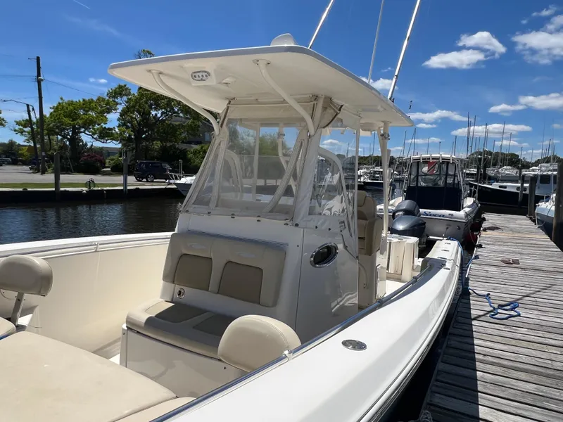 Slide: The Image of 2014 Cobia 296 Center Console boat docked under a clear blue sky. - 19