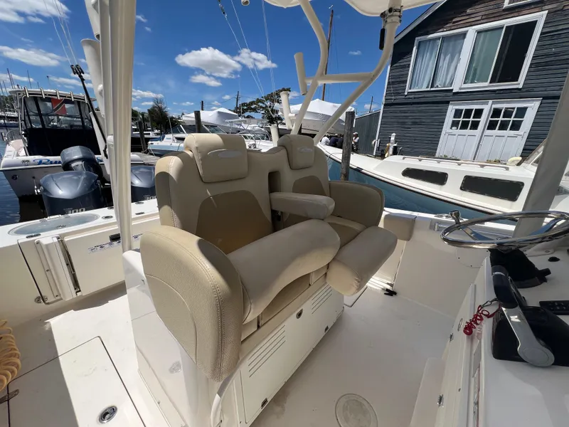 Slide: The Image of 2014 Cobia 296 Center Console boat interior with dual beige captain seats. - 24
