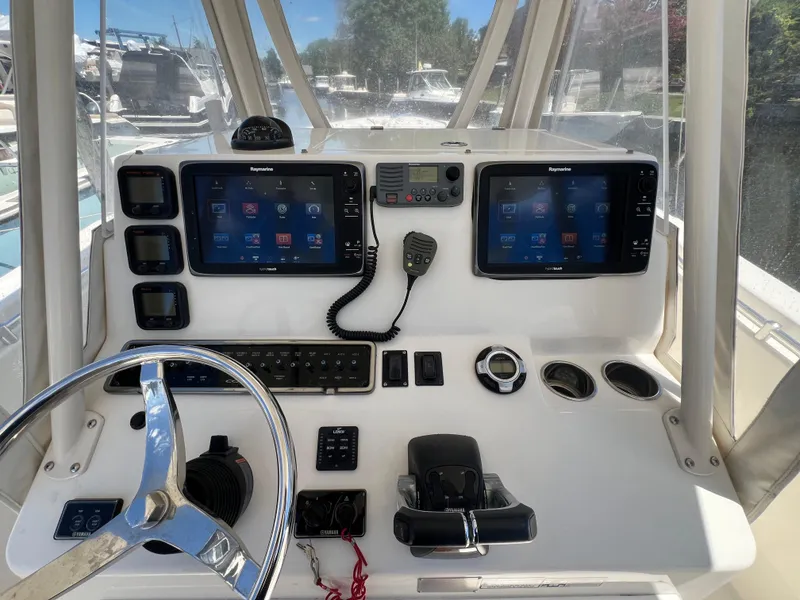 Slide: The Image of 2014 Cobia 296 Center Console dashboard with dual Raymarine displays and steering wheel. - 29