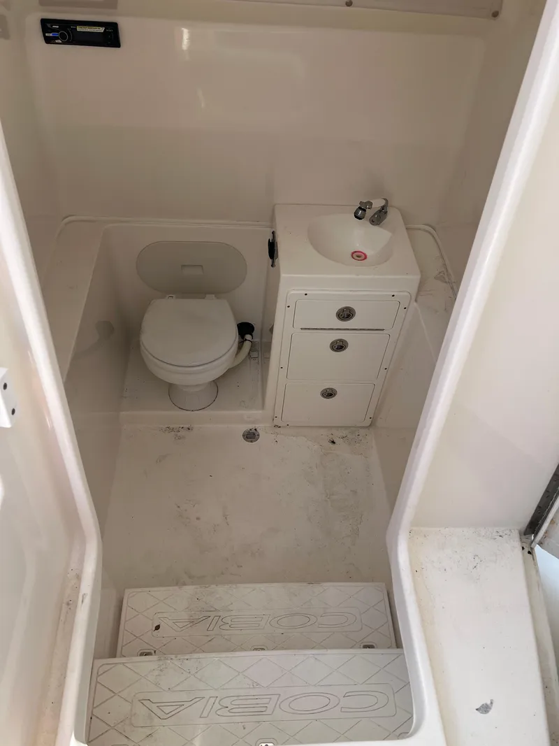 Slide: The Image of 2014 Cobia 296 Center Console boat bathroom with toilet and sink. - 34