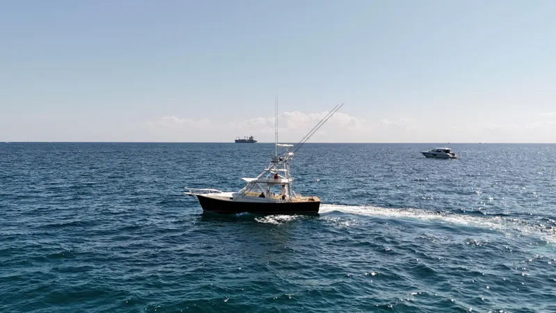 Slide: The Image of 1990 Gulf Stream Yachts 31 Tournament cruising on open sea with other boats nearby. - 14