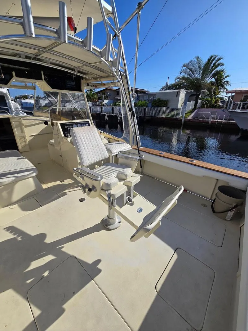 Slide: The Image of 1990 Gulf Stream Yachts 31 Tournament boat with fishing chair, docked by a canal. - 27