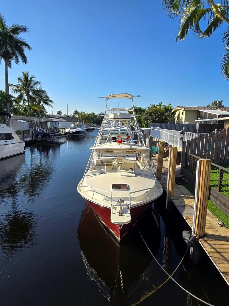Slide: The Image of 1990 Gulf Stream Yachts 31 Tournament docked in a sunny canal setting. - 29