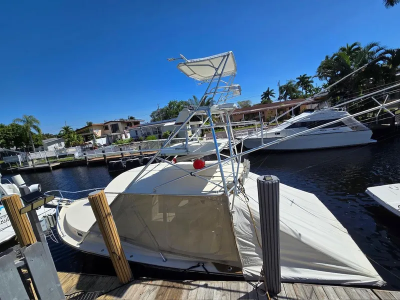 Slide: The Image of 1990 Gulf Stream Yachts 31 Tournament boat docked, partially submerged, with clear blue sky. - 38