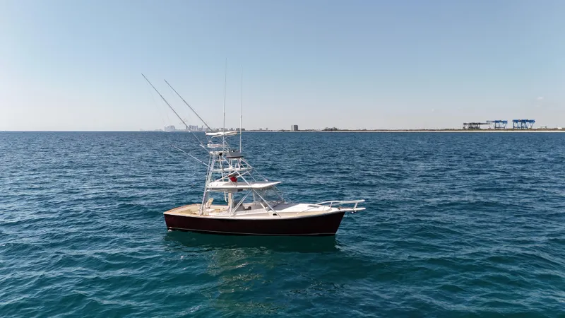 Slide: The Image of 1990 Gulf Stream Yachts 31 Tournament boat on open sea, clear sky, distant shoreline. - 4