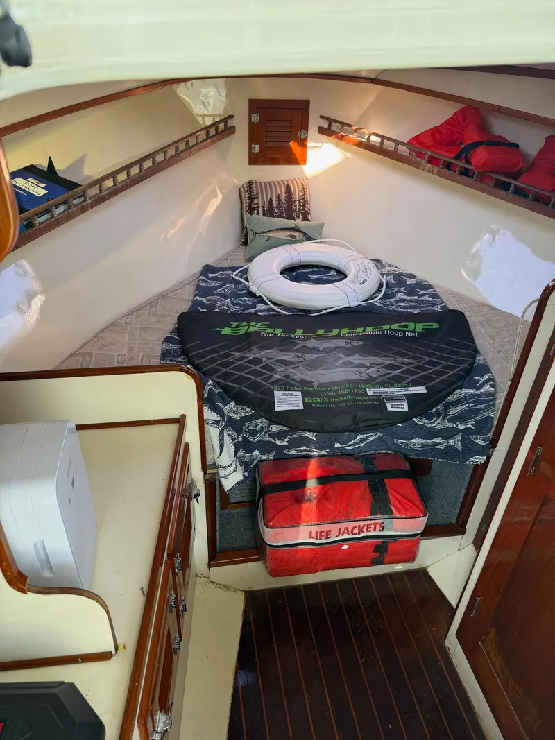 Slide: The Image of Interior of 1990 Gulf Stream Yachts 31 Tournament with bed, life jackets, and storage. - 44