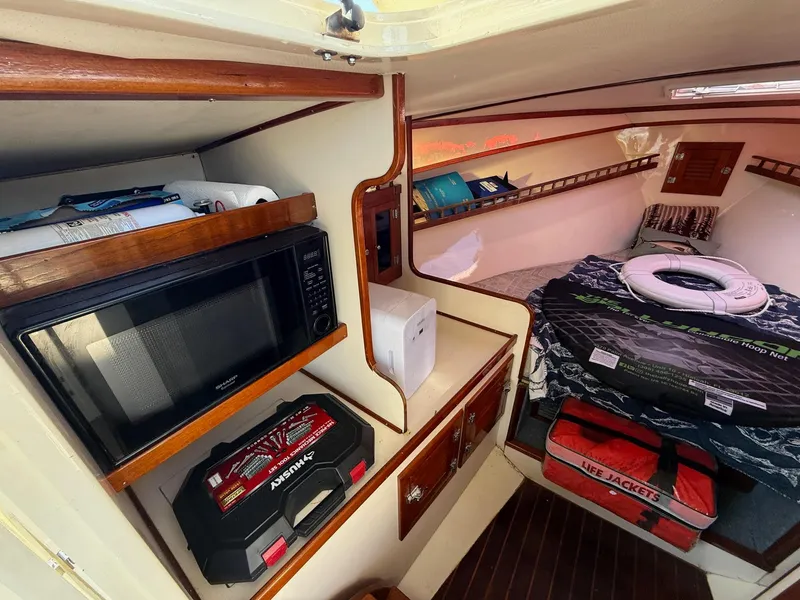Slide: The Image of Interior of 1990 Gulf Stream Yachts 31 Tournament with bed, microwave, and storage. - 47