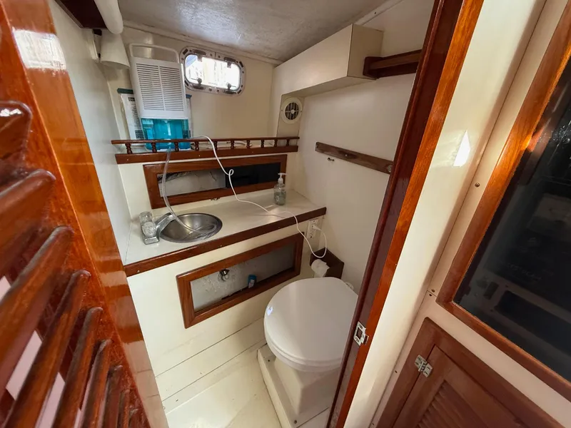 Slide: The Image of 1990 Gulf Stream Yachts 31 Tournament bathroom with sink, toilet, and wooden accents. - 49