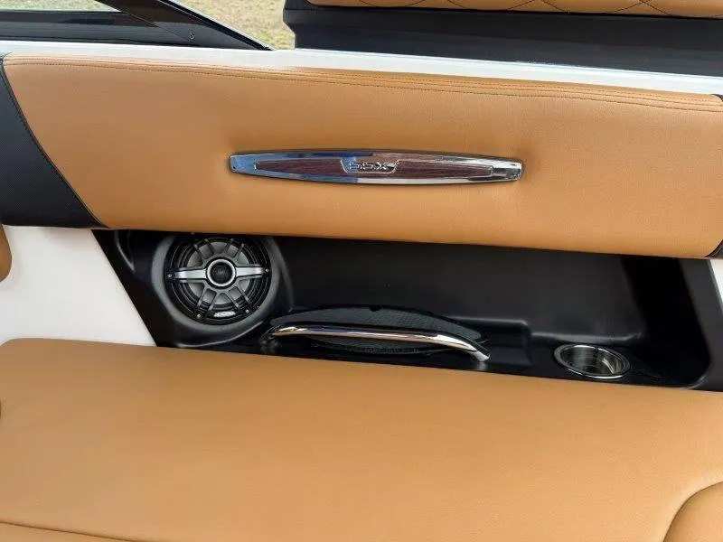 Slide: The Image of 2022 Chaparral 287 SSX boat interior with tan upholstery and speaker detail. - 14