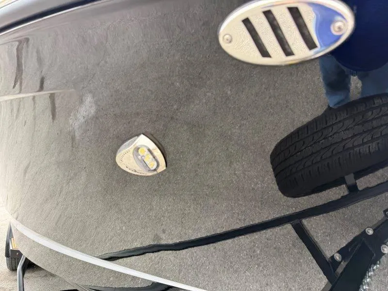 Slide: The Image of Close-up of a 2022 Chaparral 287 SSX boat hull with visible tire reflection. - 16