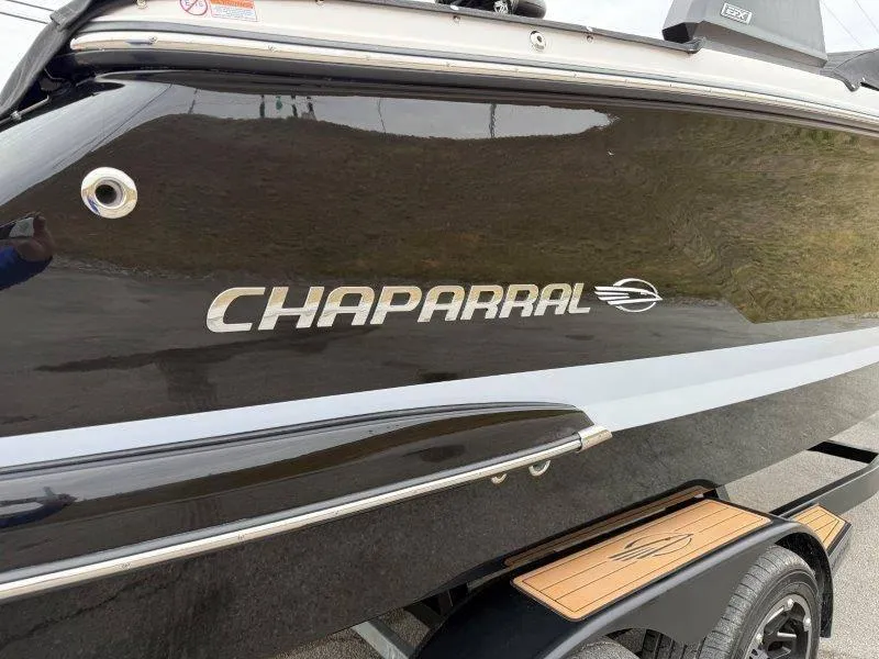 Slide: The Image of 2022 Chaparral 287 SSX boat side view with logo and sleek black finish. - 22