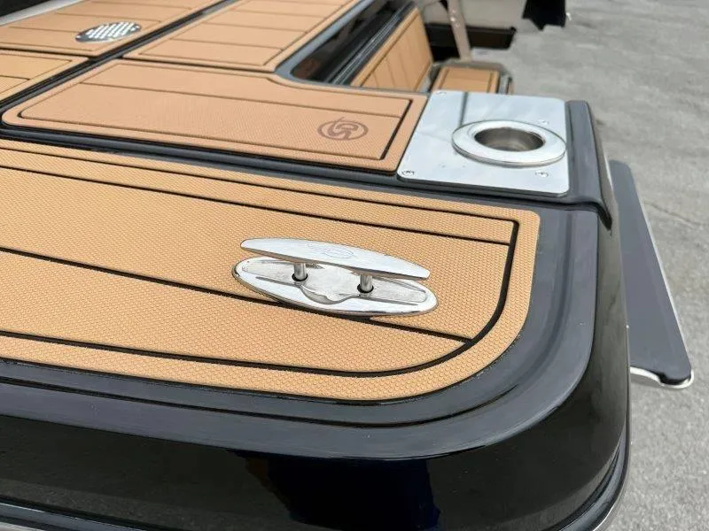 Slide: The Image of 2022 Chaparral 287 SSX boat deck with tan and black detailing, featuring a cleat and cup holder. - 27