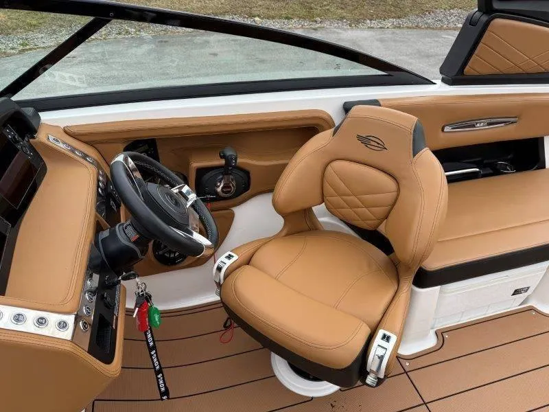 Slide: The Image of 2022 Chaparral 287 SSX boat interior with tan leather seating and modern dashboard. - 40