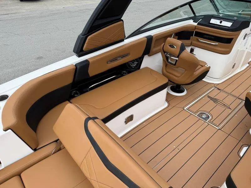 Slide: The Image of 2022 Chaparral 287 SSX boat interior with tan and black seating, sleek design. - 42