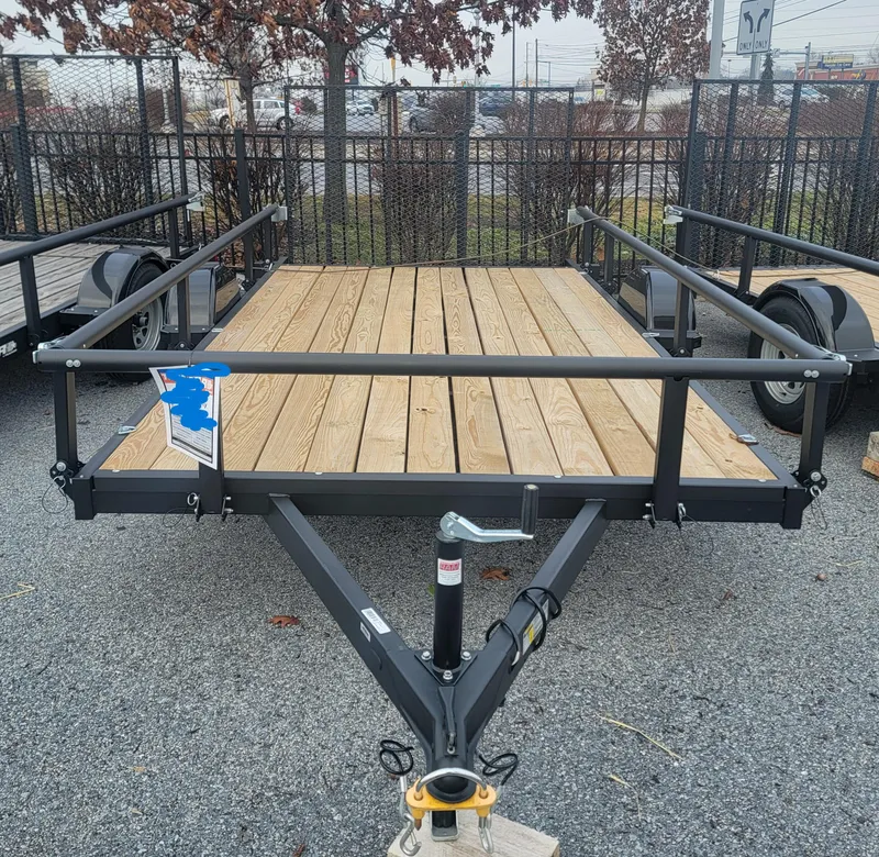 The Image of 2024 Tracker KTO-2990-82-13 utility trailer with wooden deck and metal frame. - 0