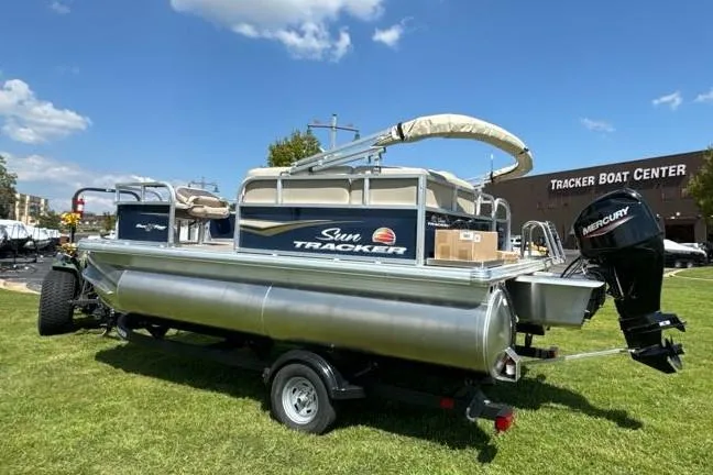 Slide: The Image of 2025 Sun Tracker Bass Buggy 16 XL Select pontoon boat on grass near Tracker Boat Center. - 3
