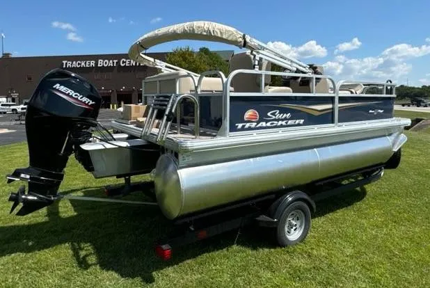 Slide: The Image of 2025 Sun Tracker Bass Buggy 16 XL Select pontoon boat on grass near Tracker Boat Center. - 6