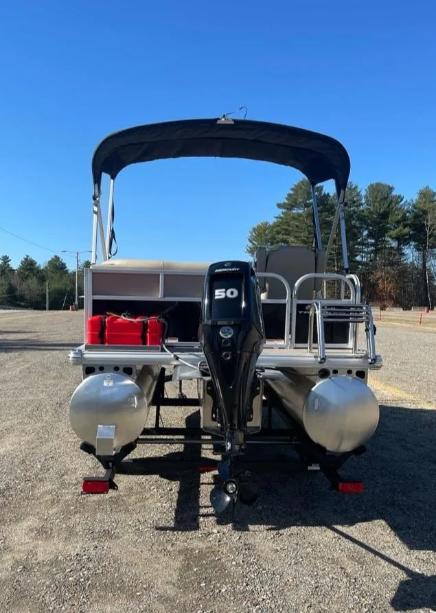 Slide: The Image of 2025 Sun Tracker Party Barge 16 DLX pontoon boat with 50 HP motor, parked outdoors. - 3