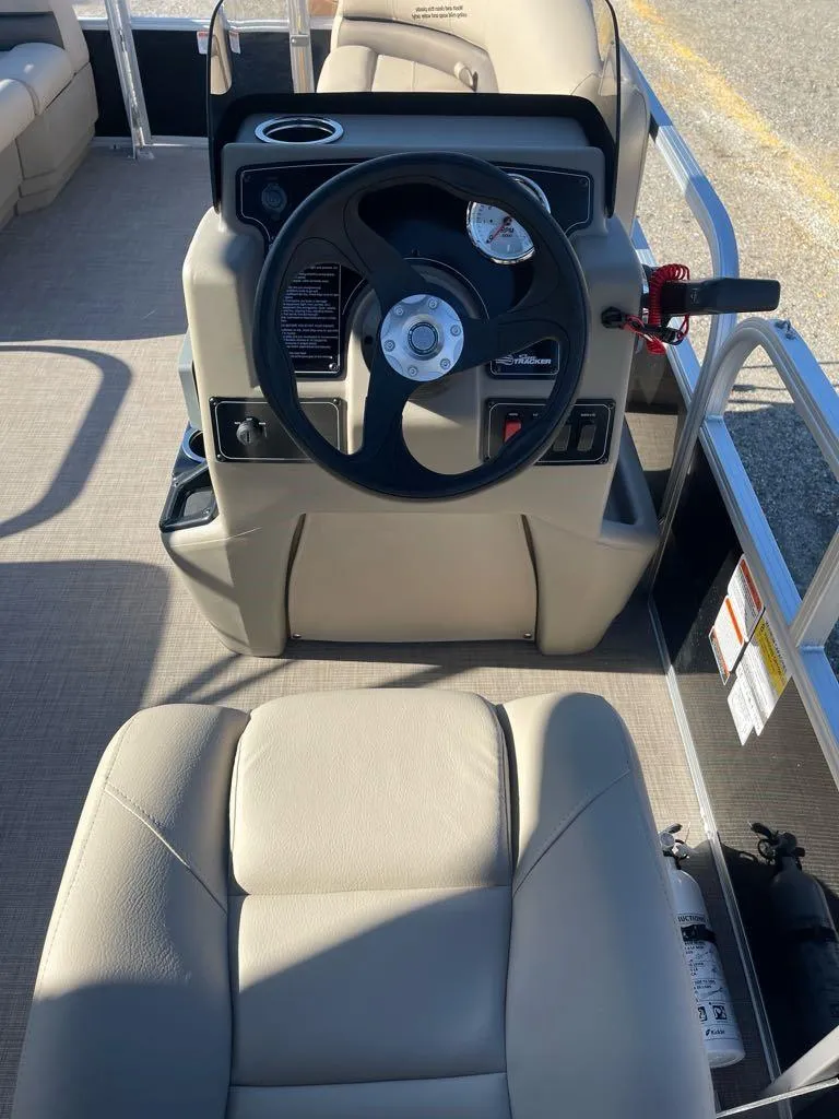 Slide: The Image of 2025 Sun Tracker Party Barge 16 DLX steering console with beige seating. - 6