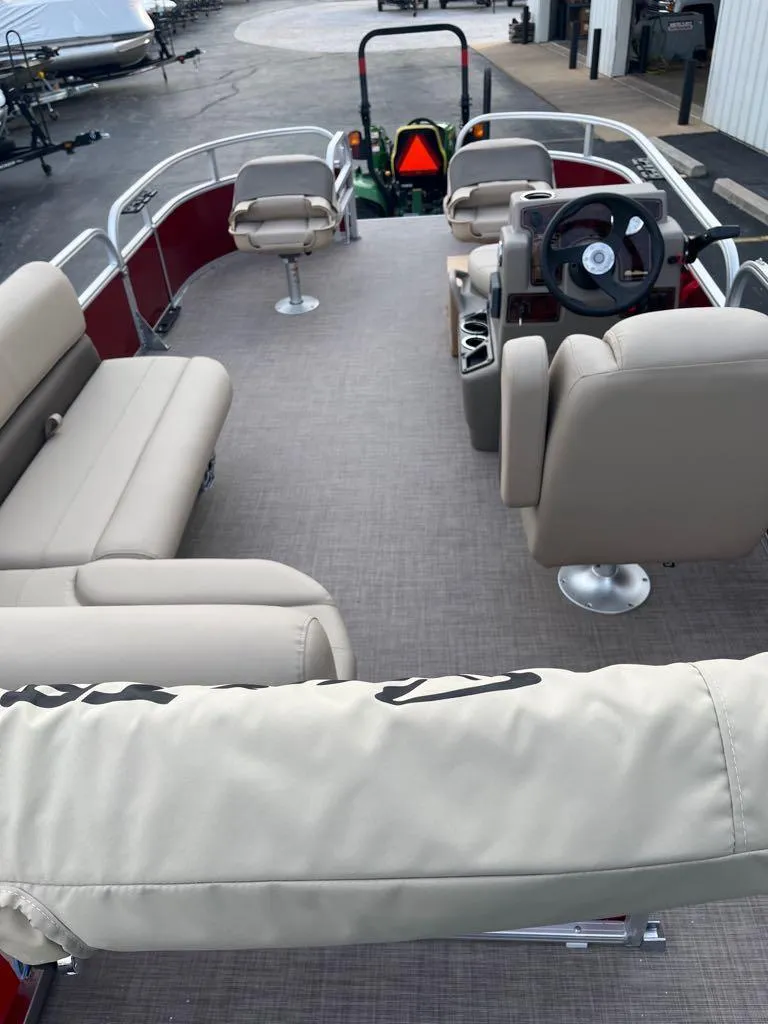 Slide: The Image of 2025 Sun Tracker Bass Buggy 16 XL Select pontoon boat interior with beige seating and steering console. - 2