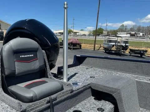 Slide: The Image of 2025 Tracker Pro Guide V-175 Combo boat interior with seating and motor, parked outdoors. - 9