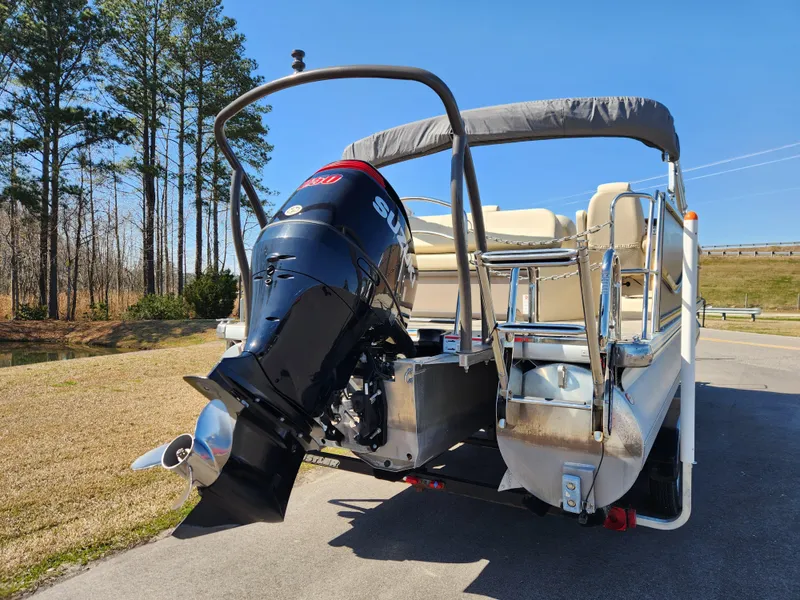 Slide: The Image of 2020 Premier 230 Sun Station pontoon boat with outboard motor, parked on a sunny day. - 3