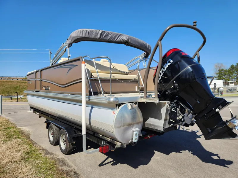 Slide: The Image of 2020 Premier 230 Sun Station pontoon boat on trailer with outboard motor, parked outdoors. - 4