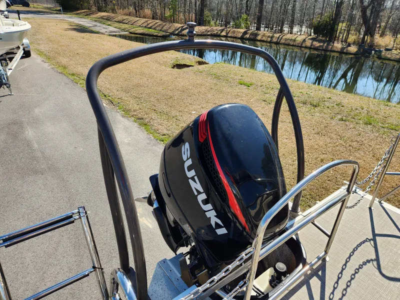 Slide: The Image of 2020 Premier 230 Sun Station with Suzuki outboard motor by a pond. - 5