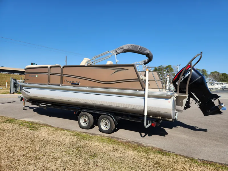 Slide: The Image of 2020 Premier 230 Sun Station pontoon boat on trailer, parked outdoors. - 6