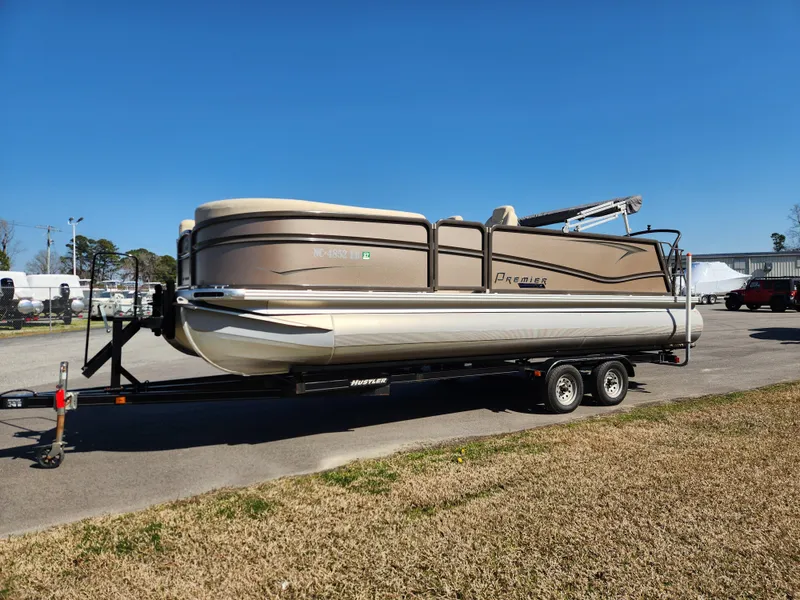 Slide: The Image of 2020 Premier 230 Sun Station pontoon boat on trailer, parked outdoors under clear blue sky. - 8