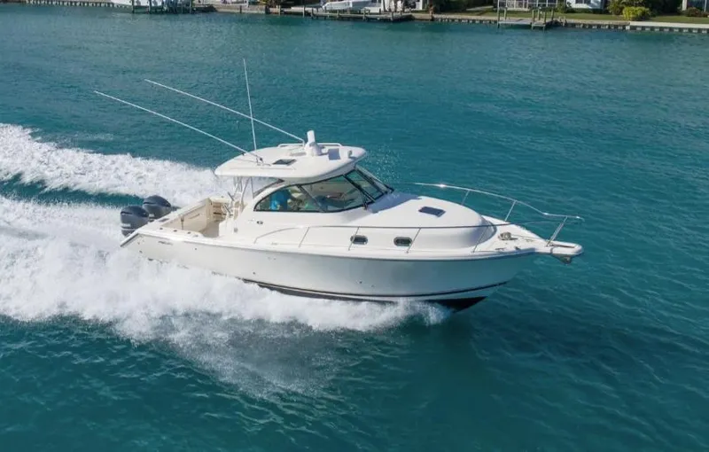 Slide: The Image of 2014 Pursuit OS 345 Offshore boat cruising on clear blue water. - 0