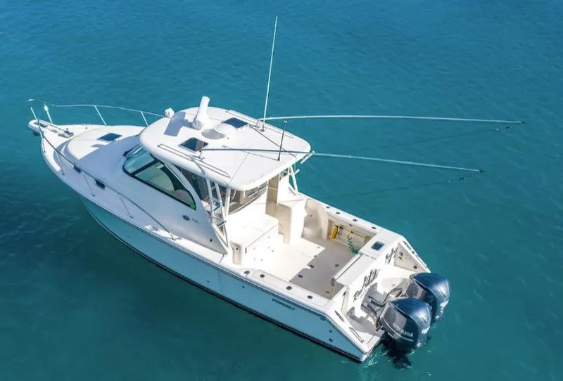 Slide: The Image of 2014 Pursuit OS 345 Offshore boat on clear blue water, aerial view. - 1
