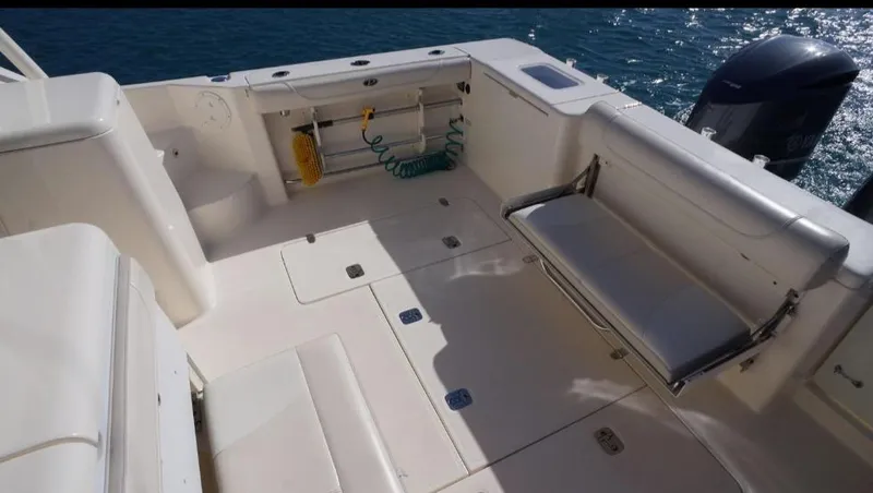 Slide: The Image of 2014 Pursuit OS 345 Offshore boat deck with seating and storage, overlooking water. - 12