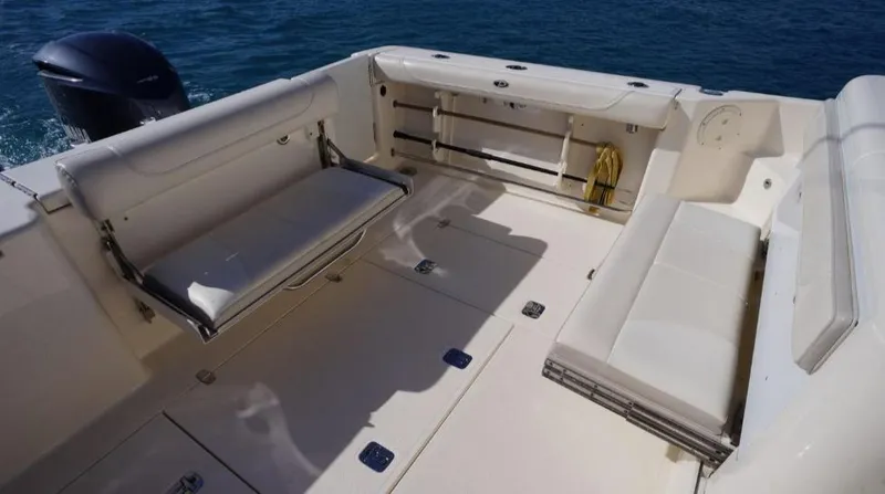 Slide: The Image of 2014 Pursuit OS 345 Offshore boat interior with seating, on calm blue water. - 18