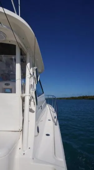 Slide: The Image of 2014 Pursuit OS 345 Offshore boat on calm blue water under clear sky. - 23