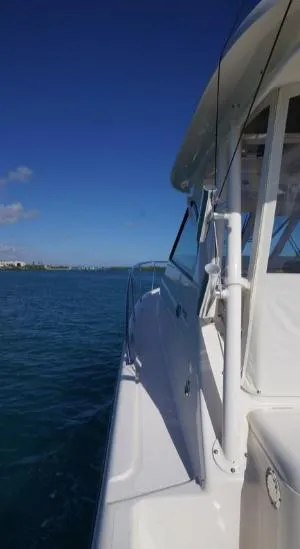 Slide: The Image of 2014 Pursuit OS 345 Offshore boat on calm blue water under clear sky. - 24